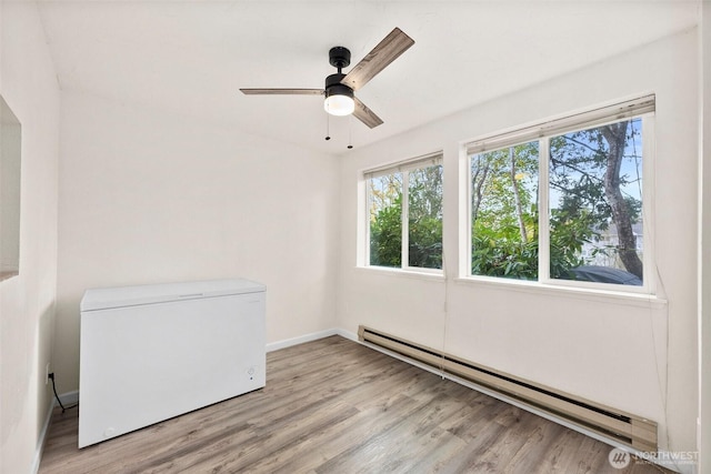 303 Kenyon St NW Unit 2D, Olympia, WA 98502 - spare room featuring a baseboard radiator, light wood-type flooring, and a ceiling fan