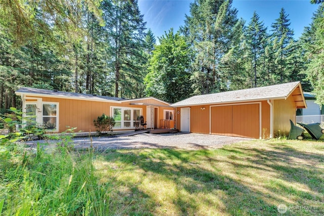 8310 207th St E, Spanaway, WA 98387 - back of house featuring an outdoor structure, a deck, a yard, and a garage