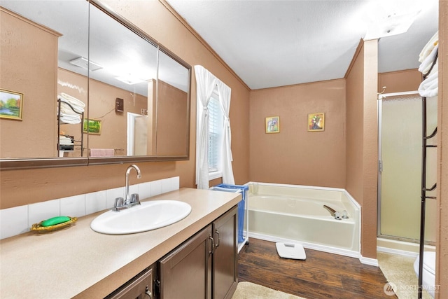 8310 207th St E, Spanaway, WA 98387 - bathroom featuring wood finished floors, vanity, a garden tub, and a shower stall