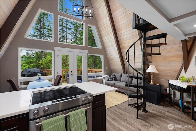 22305 Autumnwood Ct SE, Yelm, WA 98597 - living room with a towering ceiling, stairs, wooden walls, french doors, and a chandelier