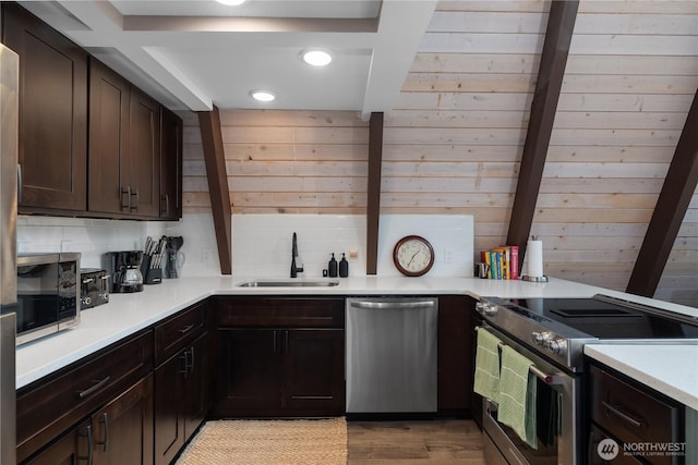 22305 Autumnwood Ct SE, Yelm, WA 98597 - kitchen featuring appliances with stainless steel finishes, dark brown cabinets, recessed lighting, light countertops, and wooden walls