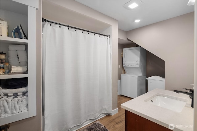22305 Autumnwood Ct SE, Yelm, WA 98597 - bathroom featuring stacked washer / dryer, wood finished floors, vanity, recessed lighting, and a shower with shower curtain