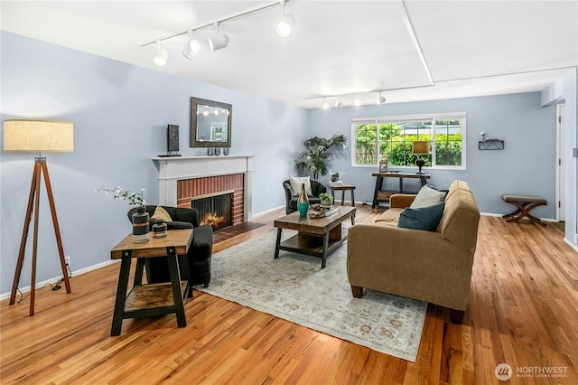 1023 144th Pl SE, Bellevue, WA 98007 - living room with rail lighting, a brick fireplace, and wood finished floors