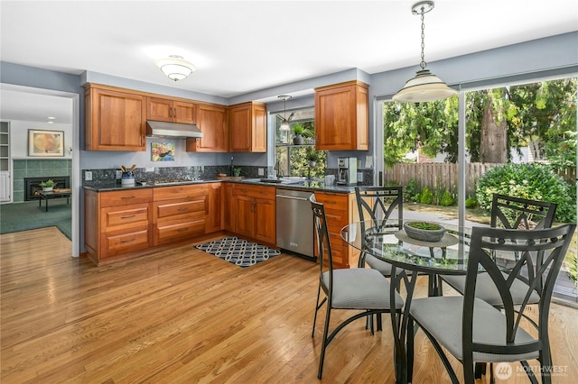 1023 144th Pl SE, Bellevue, WA 98007 - kitchen with stainless steel appliances, under cabinet range hood, hanging light fixtures, and brown cabinetry