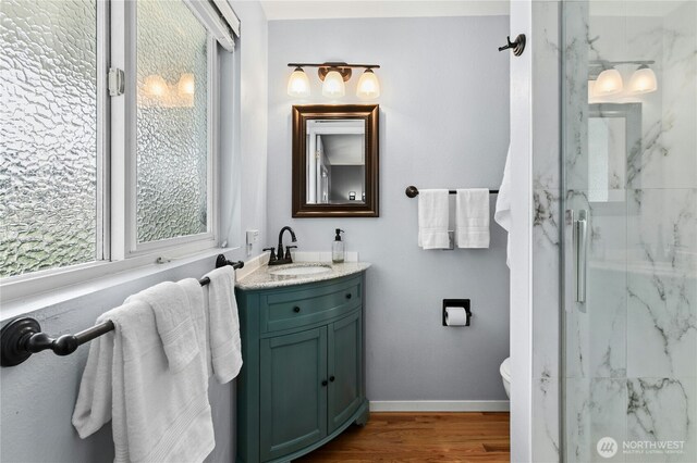 1023 144th Pl SE, Bellevue, WA 98007 - bathroom featuring a marble finish shower, vanity, and wood finished floors