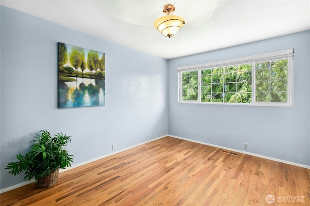 1023 144th Pl SE, Bellevue, WA 98007 - spare room with healthy amount of natural light and wood finished floors