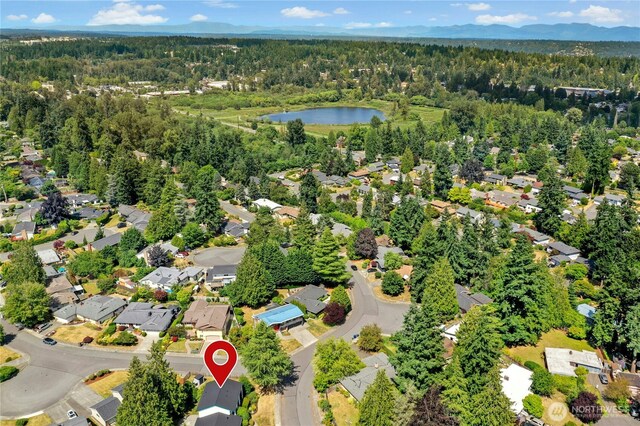1023 144th Pl SE, Bellevue, WA 98007 - aerial view of property and surrounding area featuring a heavily wooded area and nearby suburban area