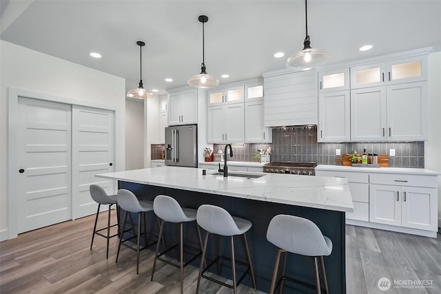 13426 108th St NE, Lake Stevens, WA 98258 - kitchen with stainless steel fridge with ice dispenser, decorative backsplash, light wood finished floors, white cabinets, and a kitchen island with sink