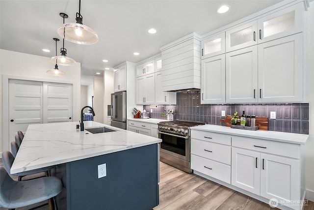 13426 108th St NE, Lake Stevens, WA 98258 - kitchen with high quality appliances, light wood-style flooring, a kitchen bar, tasteful backsplash, and an island with sink