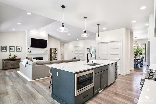 13426 108th St NE, Lake Stevens, WA 98258 - kitchen featuring appliances with stainless steel finishes, light wood-type flooring, a large fireplace, recessed lighting, and vaulted ceiling