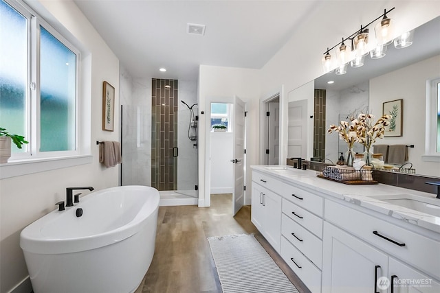 13426 108th St NE, Lake Stevens, WA 98258 - full bathroom featuring a stall shower, a soaking tub, double vanity, wood finished floors, and recessed lighting