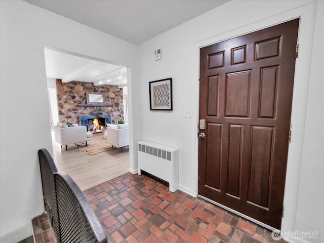 5041 Guide Meridian, Bellingham, WA 98226 - entryway with radiator heating unit, a stone fireplace, track lighting, and brick patterned flooring