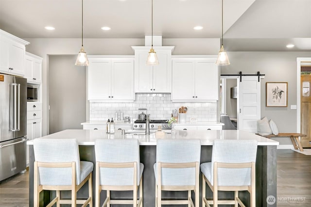 1312 Bradley Meadows Ct, Lynden, WA 98263 - kitchen featuring appliances with stainless steel finishes, light countertops, tasteful backsplash, dark wood-type flooring, and recessed lighting