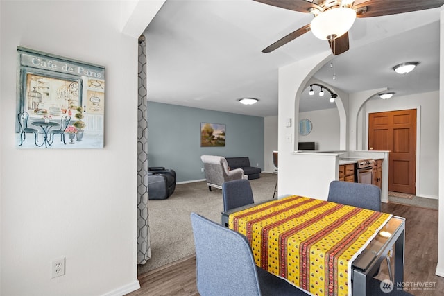 15152 65th Ave S Unit 818, Tukwila, WA 98188 - dining area featuring ceiling fan, arched walkways, and wood finished floors