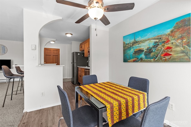 15152 65th Ave S Unit 818, Tukwila, WA 98188 - dining area featuring a ceiling fan, wood finished floors, and arched walkways