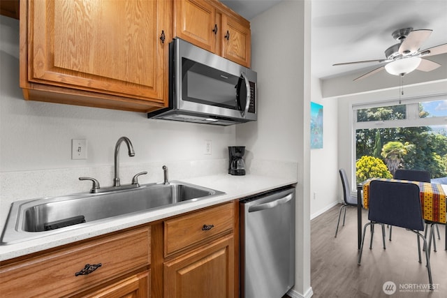 15152 65th Ave S Unit 818, Tukwila, WA 98188 - kitchen featuring appliances with stainless steel finishes, brown cabinetry, light countertops, and wood finished floors