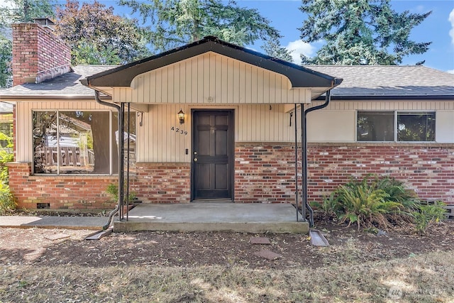 4239 S 184th Pl, Seatac, WA 98188 - doorway to property featuring brick siding, a shingled roof, and a chimney