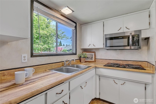 4239 S 184th Pl, Seatac, WA 98188 - kitchen featuring white cabinetry, stainless steel microwave, and black electric stovetop