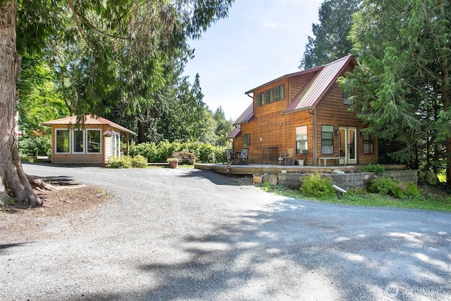3915 Gilmore Rd, Everson, WA 98247 - view of home's exterior featuring a metal roof, driveway, a standing seam roof, and a wooden deck