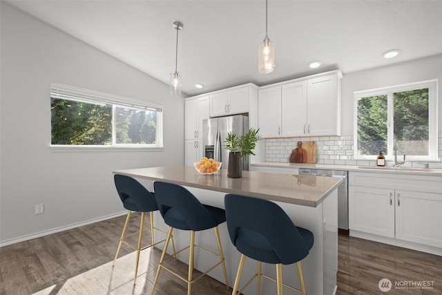 1713 S 30th St, Mount Vernon, WA 98274 - kitchen featuring stainless steel appliances, healthy amount of natural light, decorative backsplash, vaulted ceiling, and white cabinetry