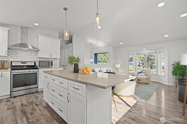 1713 S 30th St, Mount Vernon, WA 98274 - kitchen with wall chimney exhaust hood, appliances with stainless steel finishes, light countertops, wood finished floors, and recessed lighting
