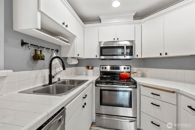 727 N 85th St Unit 102, Seattle, WA 98103 - kitchen with stainless steel appliances, white cabinetry, and tile countertops