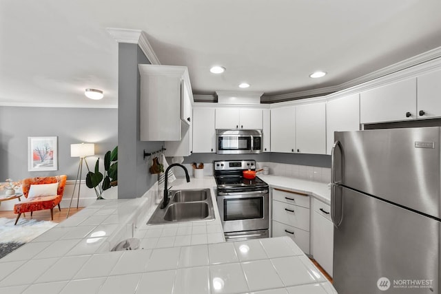 727 N 85th St Unit 102, Seattle, WA 98103 - kitchen with appliances with stainless steel finishes, tile countertops, crown molding, white cabinetry, and recessed lighting