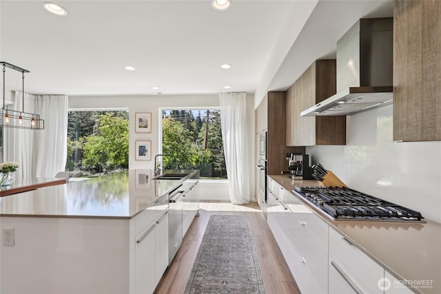 16204 27th Street Ct E, Lake Tapps, WA 98391 - kitchen with wall chimney range hood, stainless steel appliances, modern cabinets, light countertops, and light wood finished floors