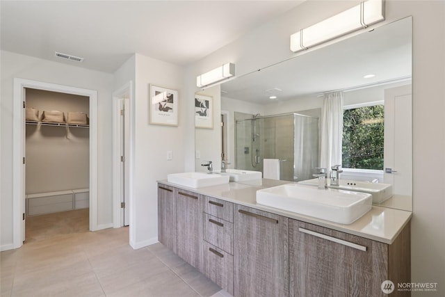 16204 27th Street Ct E, Lake Tapps, WA 98391 - bathroom with a stall shower, a walk in closet, double vanity, and tile patterned floors