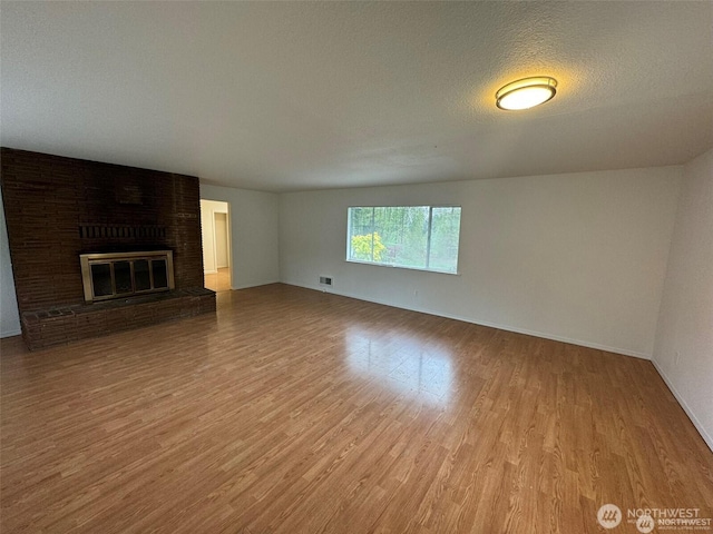 16425 Broadway Ave, Snohomish, WA 98296 - unfurnished living room with wood finished floors and a brick fireplace