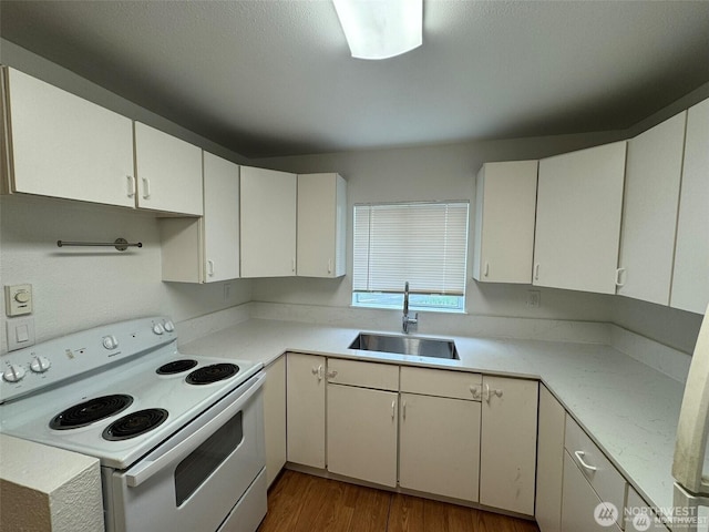 16425 Broadway Ave, Snohomish, WA 98296 - kitchen featuring white range with electric cooktop, light countertops, wood finished floors, and white cabinets