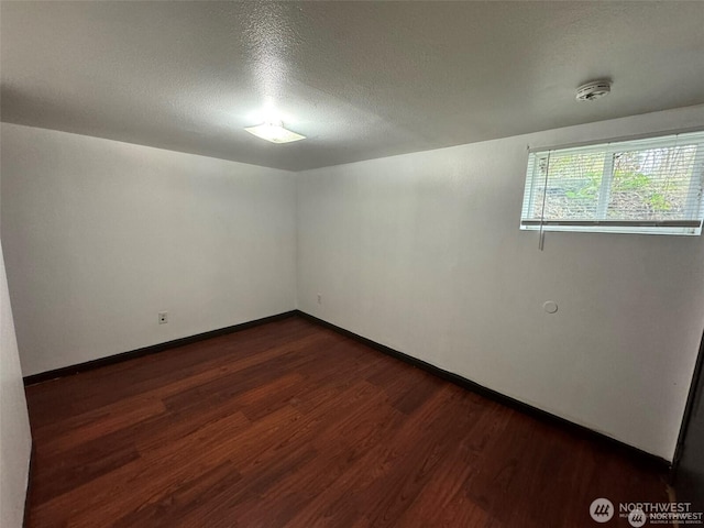16425 Broadway Ave, Snohomish, WA 98296 - unfurnished room with dark wood-style flooring, a textured ceiling, and a smoke detector