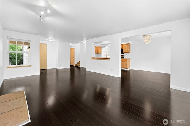 19350 113th Ave SE, Kent, WA 98031 - unfurnished living room with stairway, dark wood-style flooring, rail lighting, and a chandelier