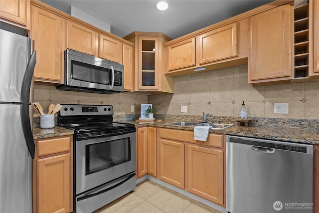 1302 N 6th St Unit 8, Tacoma, WA 98403 - kitchen featuring appliances with stainless steel finishes, backsplash, glass insert cabinets, light tile patterned floors, and dark stone countertops