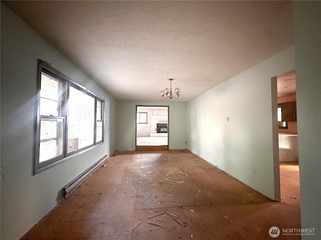 724 Hanford St, Omak, WA 98841 - unfurnished dining area with healthy amount of natural light, a baseboard radiator, a chandelier, and a textured ceiling