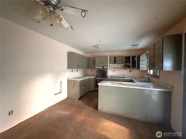 724 Hanford St, Omak, WA 98841 - kitchen with black appliances, a peninsula, gray cabinetry, under cabinet range hood, and a textured ceiling