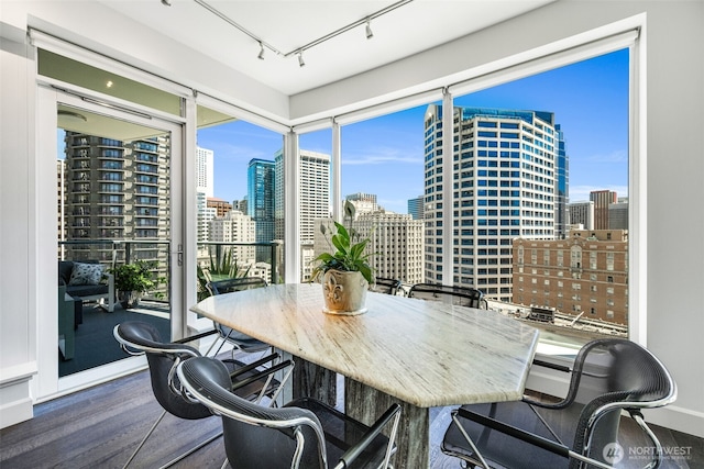 1920 4th Ave Unit 1207, Seattle, WA 98101 - dining area featuring a skyline view, track lighting, and wood finished floors