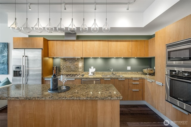 1920 4th Ave Unit 1207, Seattle, WA 98101 - kitchen featuring stainless steel appliances, track lighting, a center island, dark stone counters, and decorative backsplash