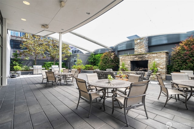 1920 4th Ave Unit 1207, Seattle, WA 98101 - wooden deck with outdoor dining space, an outdoor stone fireplace, and a patio area
