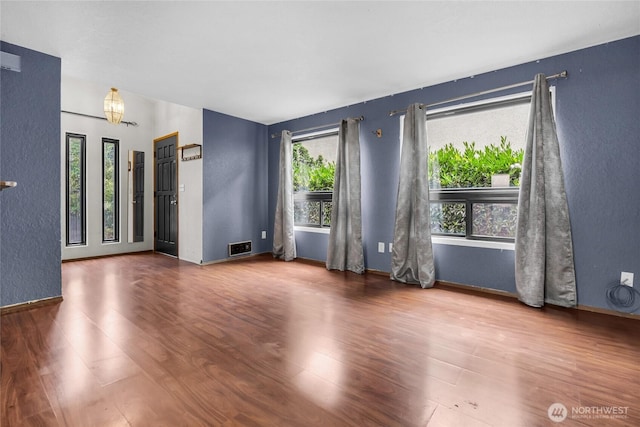 9404 Stone Ave N, Seattle, WA 98103 - unfurnished room with healthy amount of natural light, wood finished floors, and a textured wall