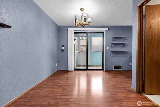 9404 Stone Ave N, Seattle, WA 98103 - unfurnished dining area with a textured wall, a chandelier, a textured ceiling, and wood finished floors