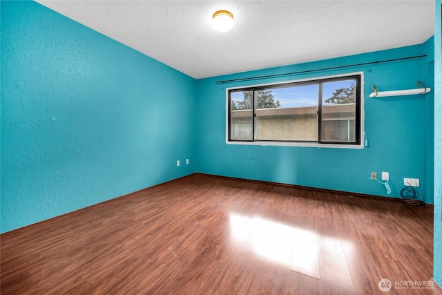 9404 Stone Ave N, Seattle, WA 98103 - empty room featuring wood finished floors, a textured wall, and a textured ceiling
