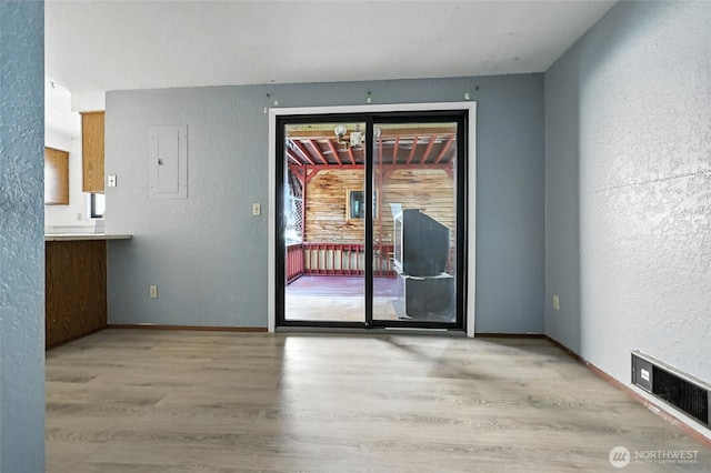9404 Stone Ave N, Seattle, WA 98103 - unfurnished dining area featuring wood finished floors, a textured wall, and electric panel