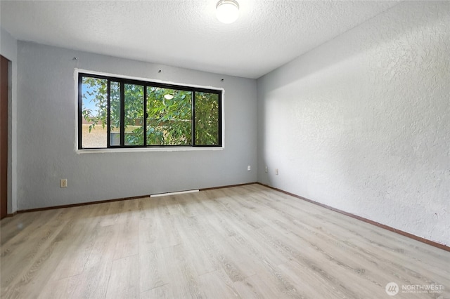 9404 Stone Ave N, Seattle, WA 98103 - spare room featuring wood finished floors, a textured ceiling, and a textured wall