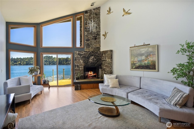 140 Admiralty Ln Unit 370, Port Ludlow, WA 98365 - living room with wood finished floors, a water view, a stone fireplace, and high vaulted ceiling