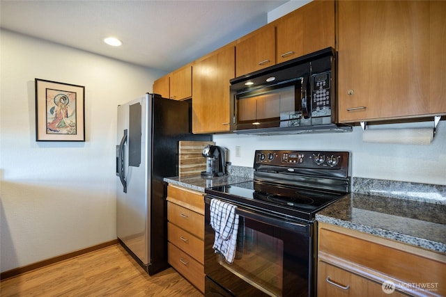 140 Admiralty Ln Unit 370, Port Ludlow, WA 98365 - kitchen with black appliances, brown cabinets, light wood-style floors, dark stone countertops, and recessed lighting