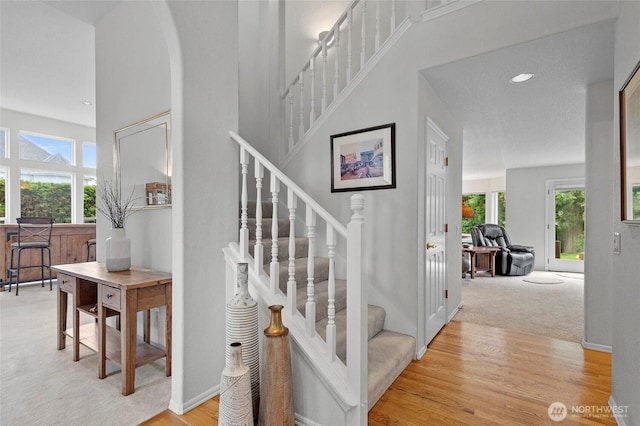 4015 E Broadway St, Mount Vernon, WA 98274 - staircase with wood finished floors, a high ceiling, carpet floors, arched walkways, and recessed lighting