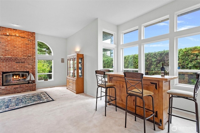 4015 E Broadway St, Mount Vernon, WA 98274 - kitchen featuring light carpet, a fireplace, a breakfast bar, and light countertops