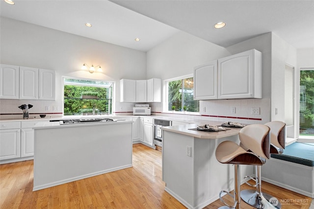 4015 E Broadway St, Mount Vernon, WA 98274 - kitchen with white cabinetry, backsplash, a peninsula, and recessed lighting