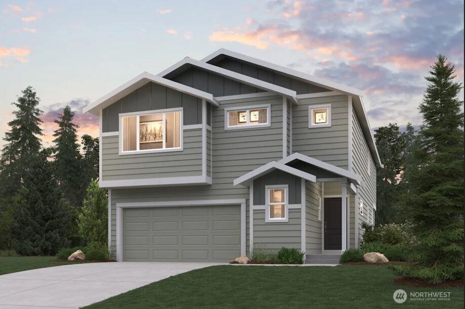 13421 323rd Pl SE Unit 217, Sultan, WA 98294 - view of front facade with concrete driveway, board and batten siding, an attached garage, and a lawn